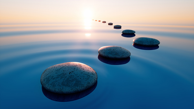 Stones in calm water with evening sun