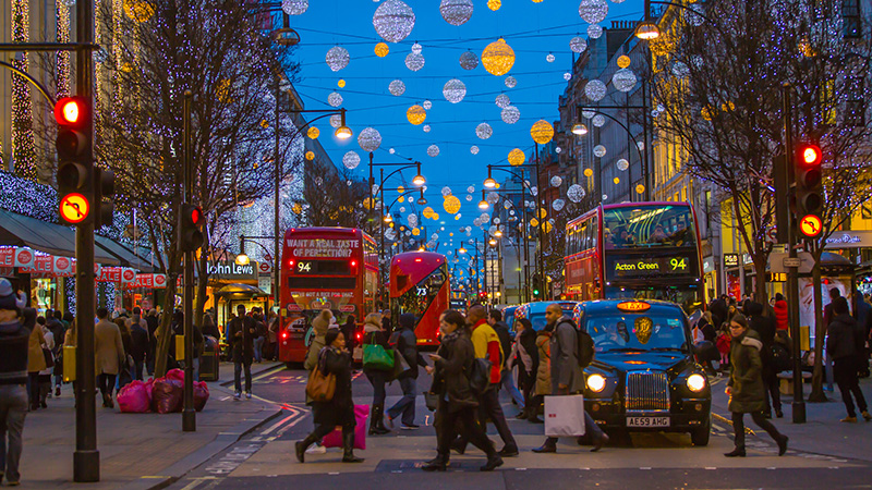 London, UK - December 30, 2015: Christmas lights decoration at Oxford street and lots of people walking during the Christmas sale, public transport, buses and taxies