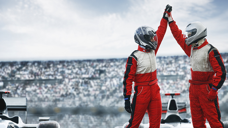 Two racing drivers celebrate a win